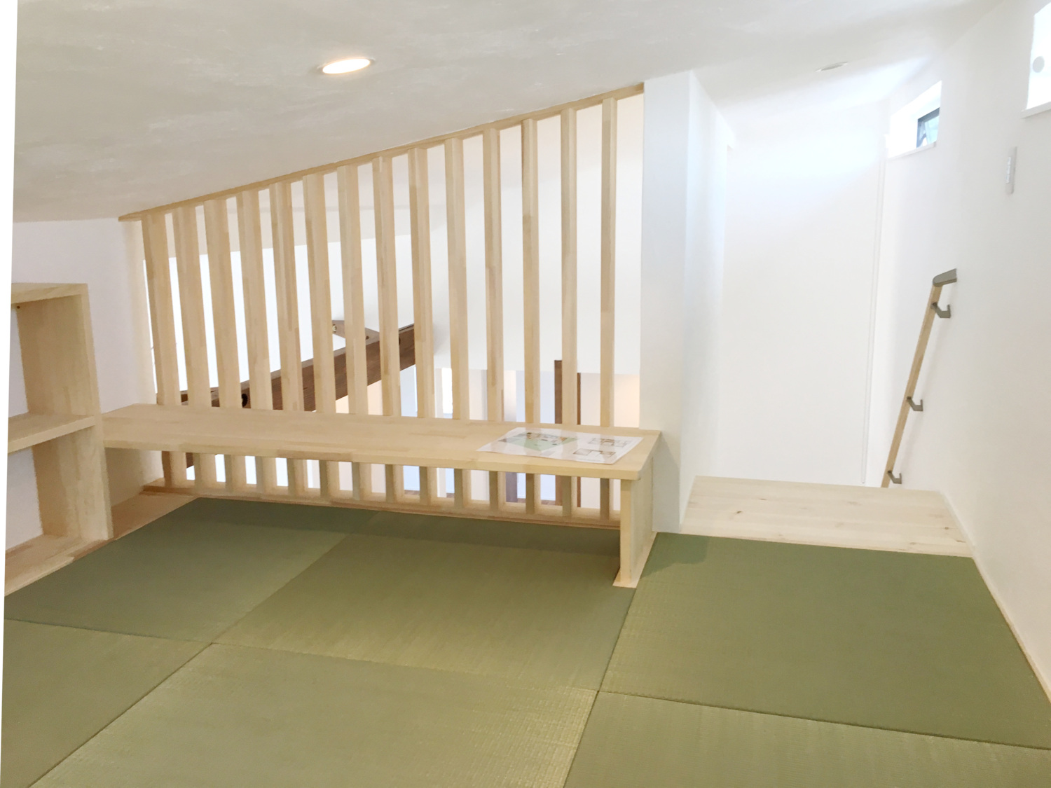 鉄骨階段と木製スリットが調和する開放的な吹き抜けの家。